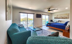 Une chambre moderne avec un lit, un canapé, une table basse et un balcon offrant une vue agréable.