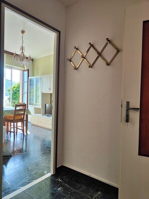 A room with a door, a chandelier, and a wall-mounted decorative piece.
