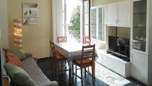 Un rincón comedor acogedor con una mesa y sillas, un sofá y un televisor.