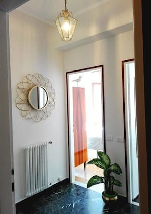 Stylish hallway with a round mirror, radiator, and potted plant.