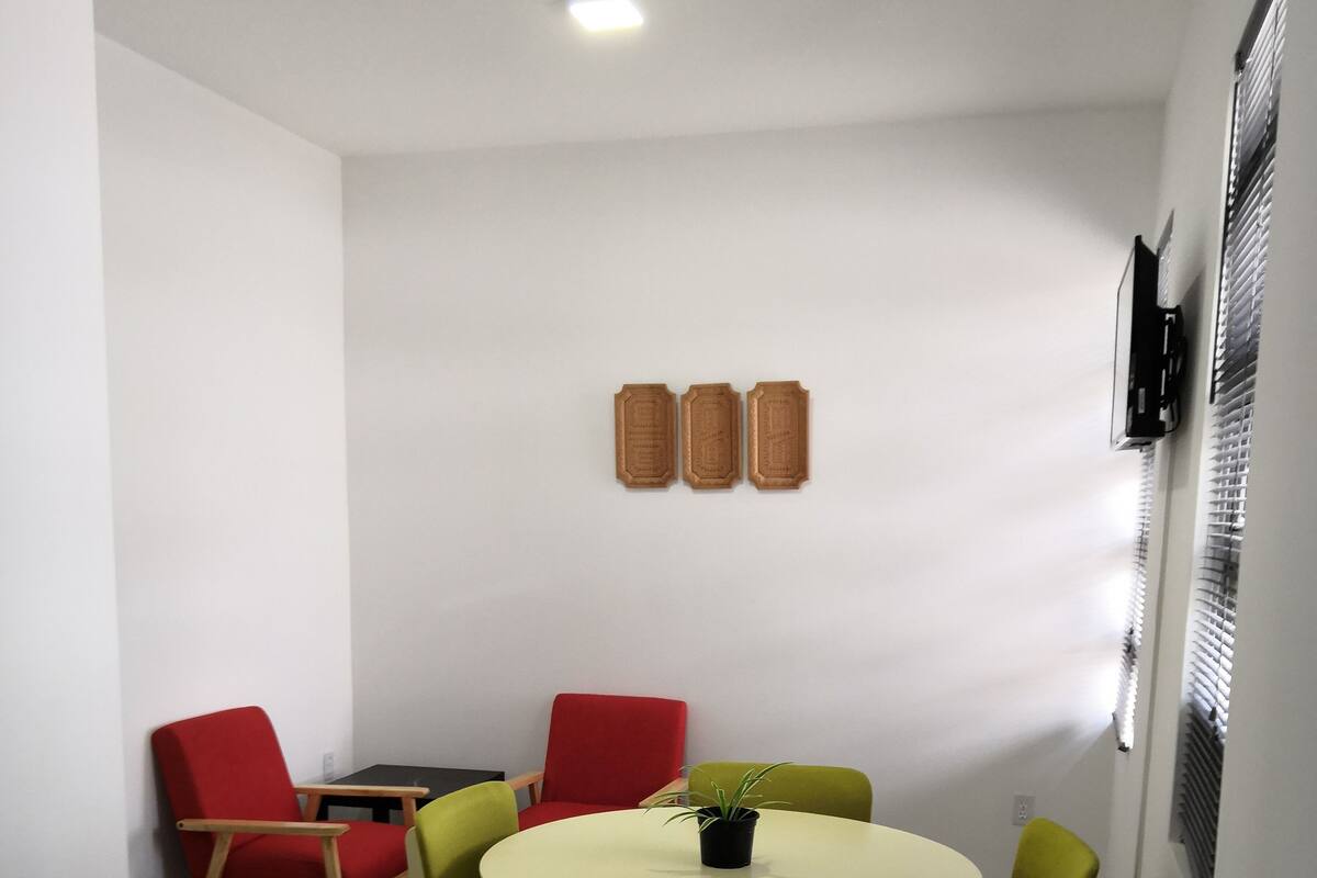 A small dining area with a round table, four chairs, and a potted plant.