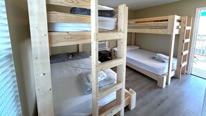 Et værelse med køjeseng, et vindue og en dør.