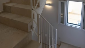 A staircase with beige steps and white railings, leading to a landing with a window. - Historic citycentre apartment with breathtaking views (Monopoli)