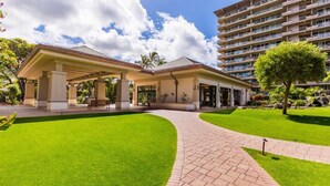 A hotel with a covered outdoor area, a well-maintained lawn, and a brick pathway leading to the entrance. - AMAZING VIEW!  1 Back from Oceanfront 1bed/2 bath (Lahaina)
