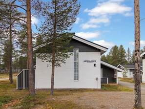 A small, single-story building with a white exterior and a dark roof, labeled 'KÄTÄKÄLÄINEN' with a mailbox and a door.
