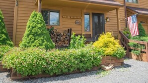 A two-story wooden building with a porch, numbered 165, and an American flag. - Cozy, Beautifully Furnished Condo 10  Minutes to Ski Resorts (Davis)