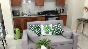 A modern kitchen with wooden cabinets, a microwave, a stove, and a sink.