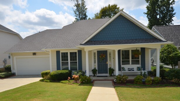 A two-story house with a front porch, a garage, and a well-maintained lawn. - Magnolia Gardens NEW (Grovetown)