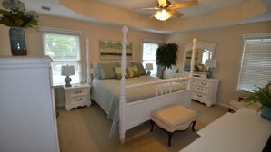 A bedroom with a four-poster bed, bedside tables, a ceiling fan, and a window with blinds. - Magnolia Gardens NEW (Grovetown)