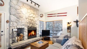 A cozy living room with a stone fireplace, a flat-screen TV, and a comfortable sofa. - Ski to the door!True SI/SO Luxury 2BrTH-Private HT (Whistler)
