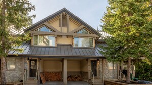 A two-story house with a stone facade, a covered porch, and a garage. - Ski to the door!True SI/SO Luxury 2BrTH-Private HT (Whistler)