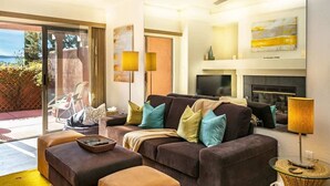 Een moderne woonkamer met een bank, een poef en een televisie.