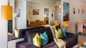 Een moderne woonkamer met een bank, lampen en kunstwerken.