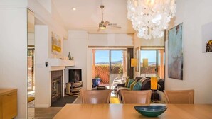 Een moderne woonkamer met een eethoek, een open haard en uitzicht op de omgeving.