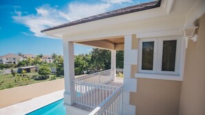 Ein Wohnhaus mit überdachter Terrasse, Swimmingpool und Blick auf die Nachbarhäuser.