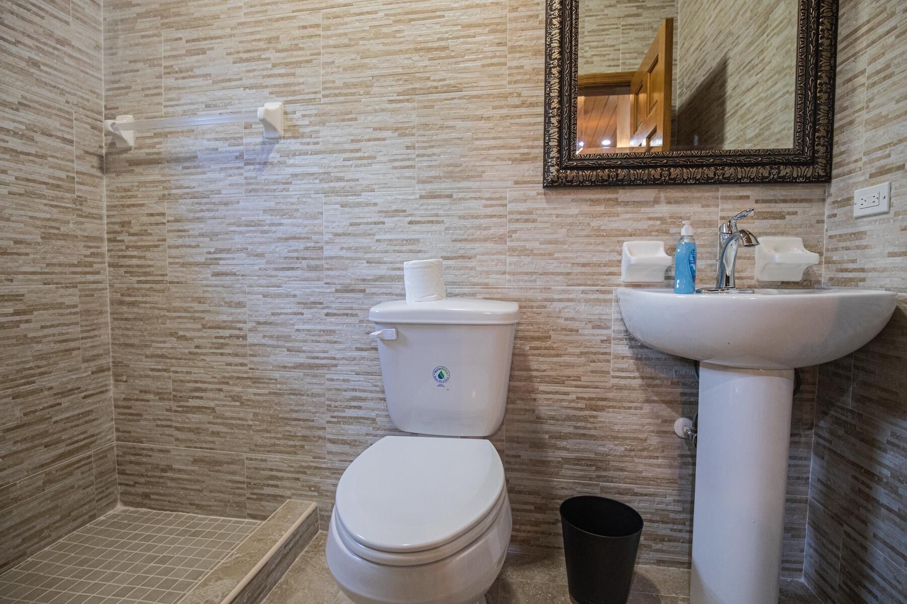Un baño con inodoro, lavabo y espejo.