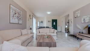 Un salón amplio con un sofá beige grande, una mesa de centro de madera y un diseño minimalista.
