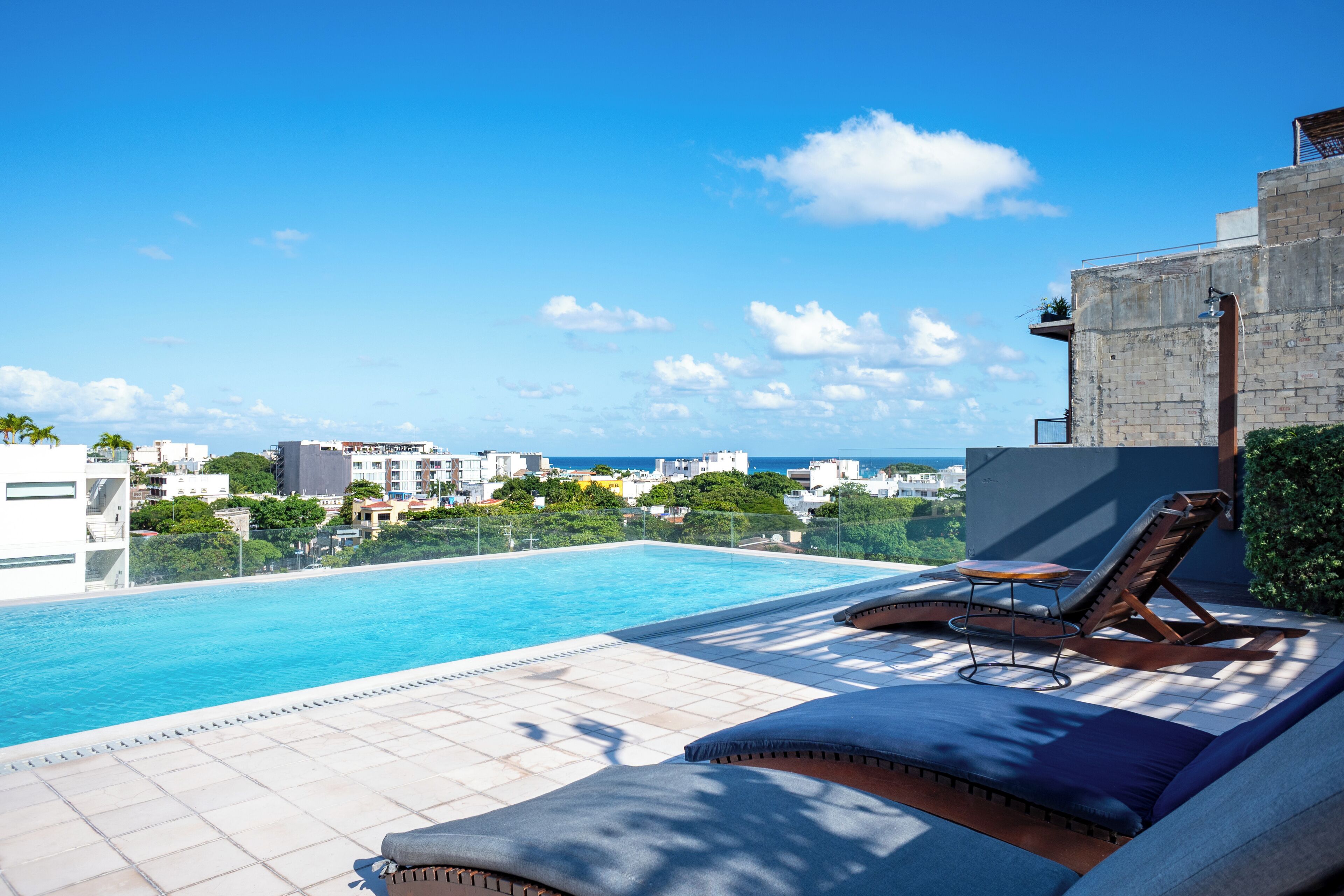 A rooftop pool with lounge chairs and a view of the cityscape.