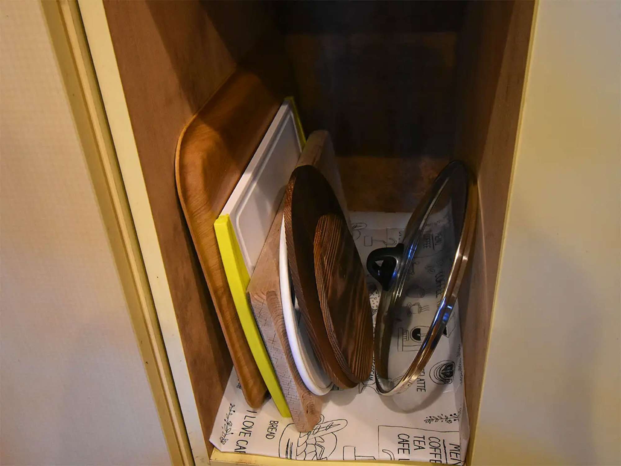 A kitchen cabinet with various utensils and a menu.