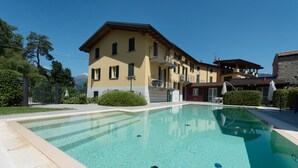 Une grande piscine rectangulaire à l’eau d’un bleu limpide, entourée d’une terrasse blanche.