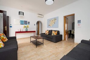 A modern living room with a sofa, a coffee table, and a map on the wall.
