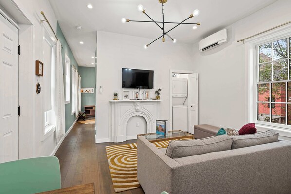 A modern living room with a fireplace, a sofa, and a television.