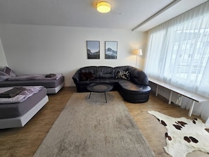 A modern living room with a sectional sofa, a round coffee table, a rug, and a cowhide rug.