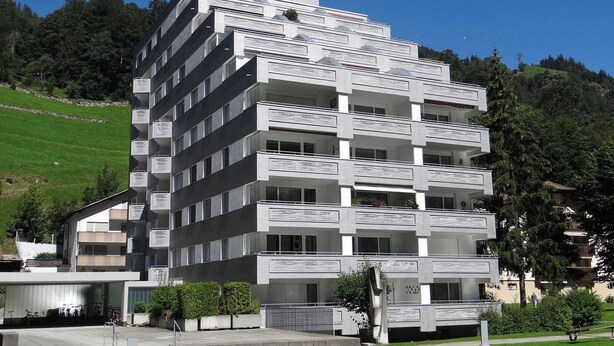 A multi-story building with balconies, a parking area, and a sculpture in the foreground. - Sunnmatt 752 Appartement/Fewo 3-Bettwohnung by Interhome (Engelberg)