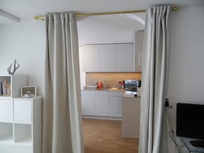 A modern kitchen with white cabinets, a microwave, and a sink.
