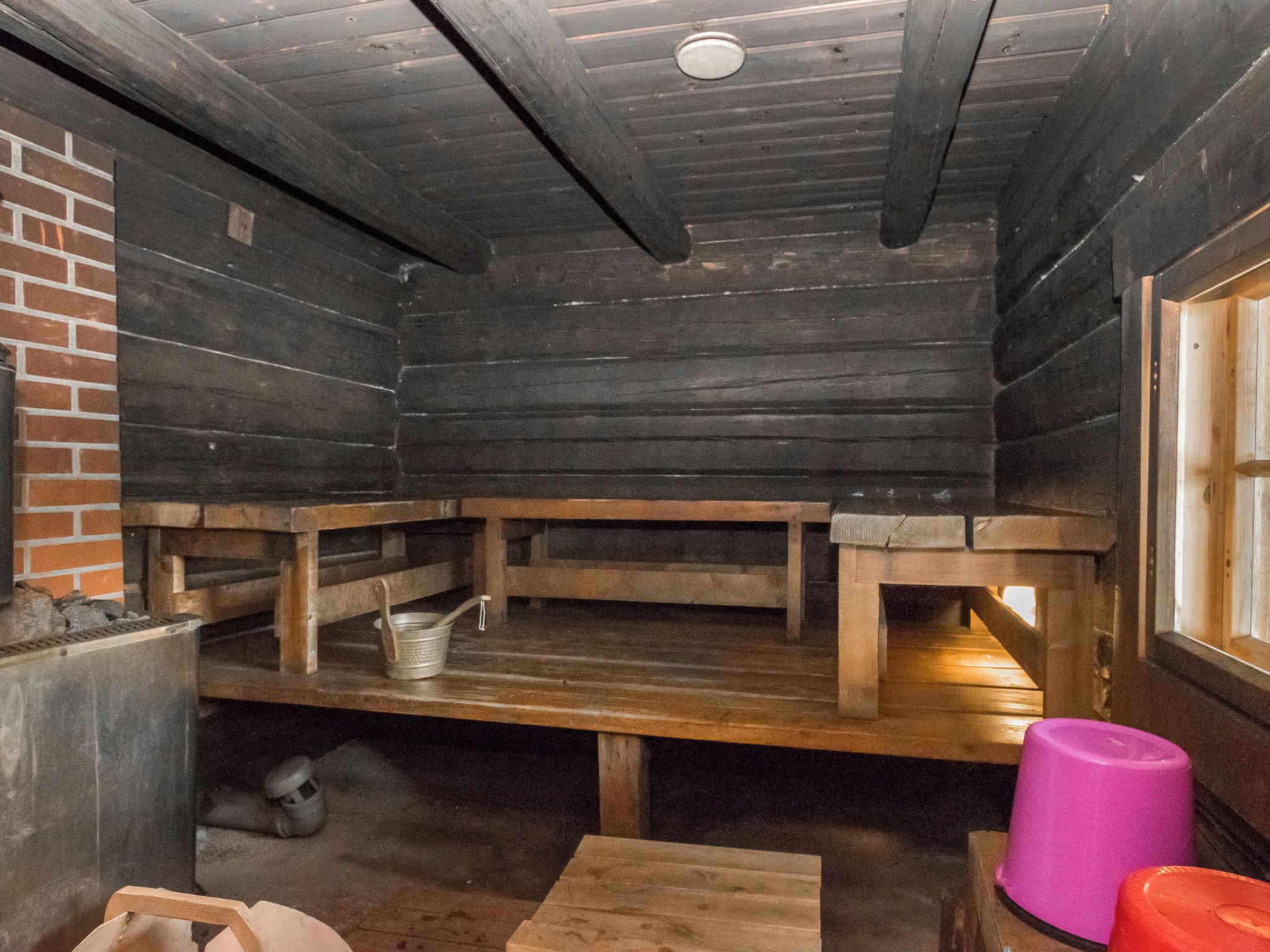 Ein rustikaler Holzraum mit Bänken und einer Ziegelwand.