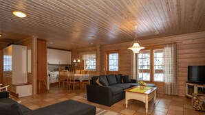 Una habitación acogedora de estilo cabaña, con comedor, sofá y televisor.