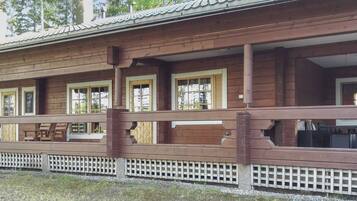 A wooden building with multiple windows and a covered porch area.
