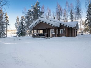 Een lodge met een overdekte veranda en een auto ervoor geparkeerd.