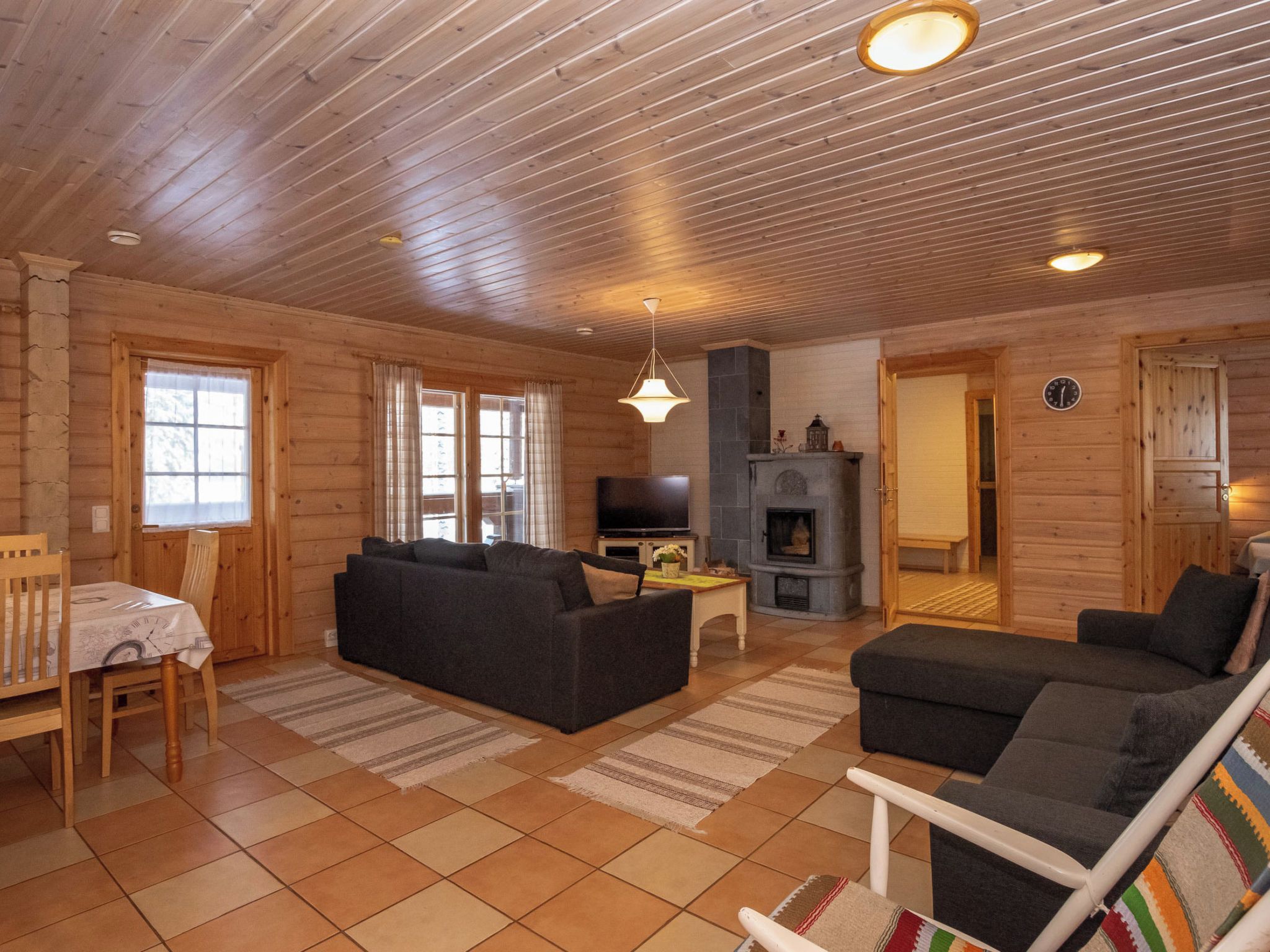 Una sala de estar acogedora con un sofá, televisor, chimenea y comedor con mesa y sillas.