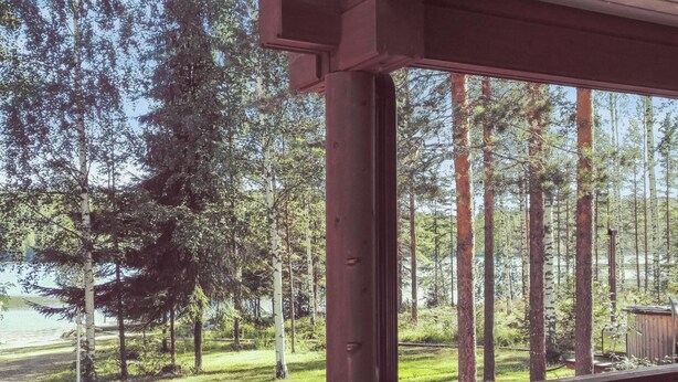Una terraza de madera con vistas a un bosque y un lago.