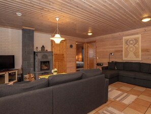 A modern living room with a fireplace, a sofa set, and a television.