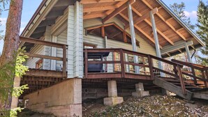 A wooden cabin with a steeply pitched roof, a wooden deck, and a staircase leading to an upper level. - Leijankorpi by Interhome (Pöytyä)