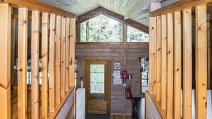 A wooden cabin interior with a central door, wooden railings, and a small table. - Leijankorpi by Interhome (Pöytyä)