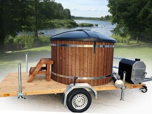 A portable sauna with a wooden exterior, a metal frame, and a grill attached. - Jussinlahti, vaikon loma 6 by Interhome (Kaavi)