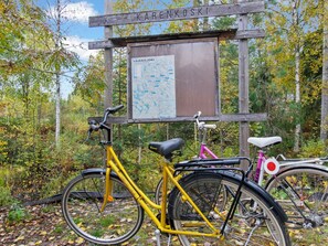 A wooden sign with 'KAREN KOSKI' and a map, two bicycles, and a forested area. - Jussinlahti, vaikon loma 6 by Interhome (Kaavi)