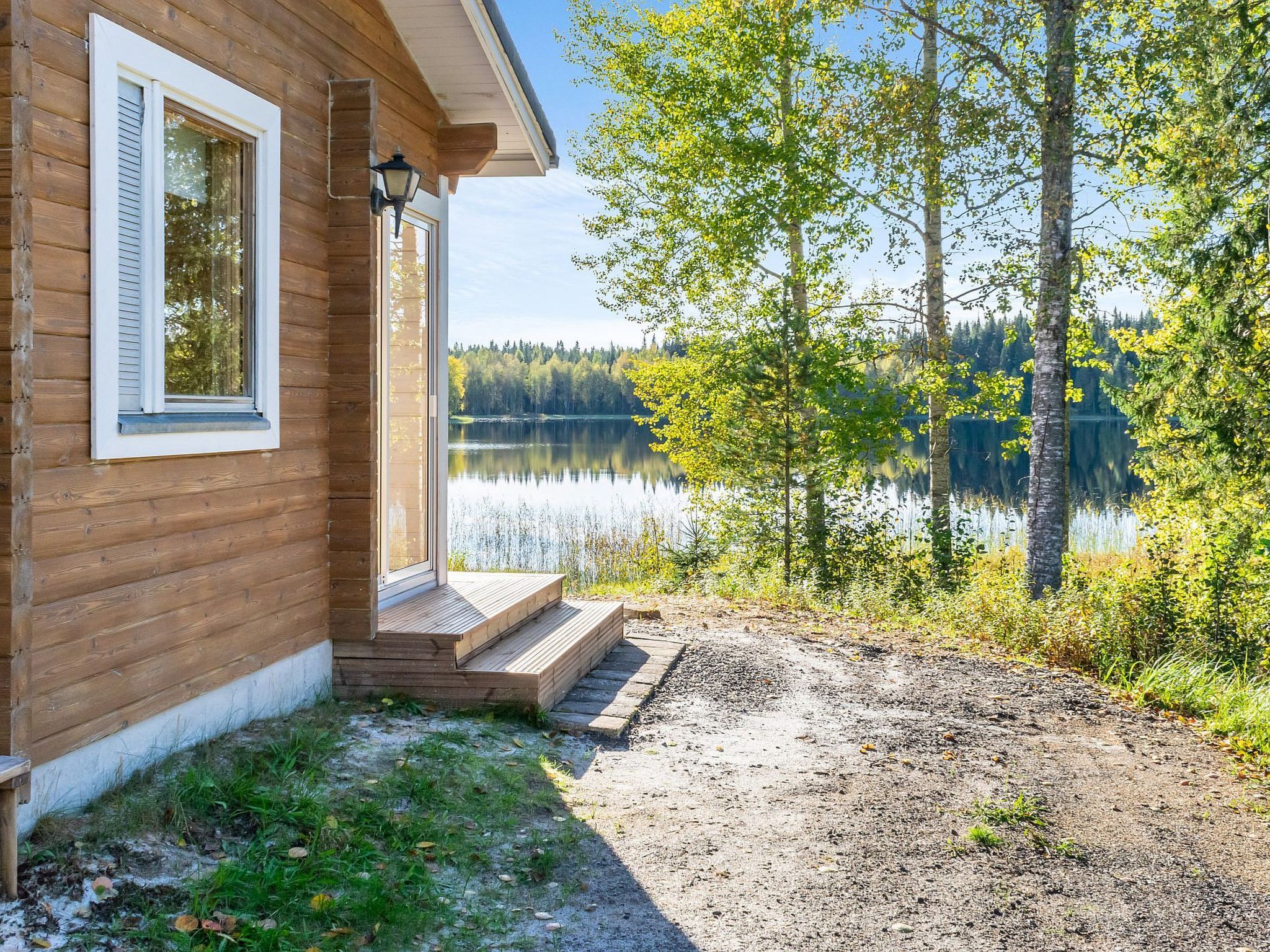 Puinen mökki, jossa on kuisti ja josta avautuu näkymä järvelle.