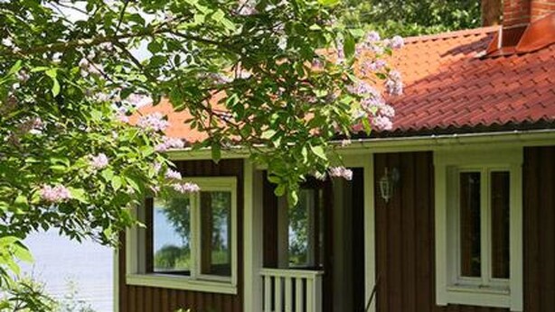 A wooden house with a red roof and a porch. The name 'RANTASAUNA' is visible on the side. - Vacation home Monaco by Interhome (Asikkala)