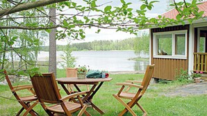 A wooden deck with two folding chairs and a small table, overlooking a lake. - Vacation home Monaco by Interhome (Asikkala)