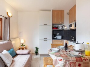 A compact living space with a kitchenette, a dining area, and a sofa.