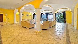 A spacious living area with yellow walls, white arches, and beige sofas. - St Anthony by Interhome (Jávea)