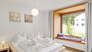 Een moderne slaapkamer met een bed, bedlampjes en kunst aan de muur.