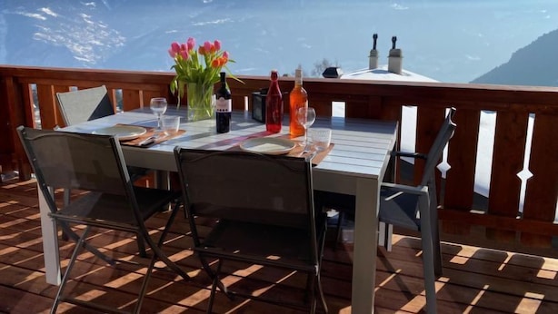 Ein Tisch für zwei Personen mit Blick auf schneebedeckte Berge.