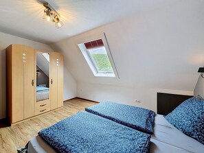 A bedroom with a skylight, a wardrobe, and a bed with patterned bedding. - Eifelhome Two nahe Nürburgring by Interhome (Antweiler)