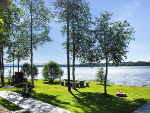 A lakeside patio with picnic tables and a grill, surrounded by trees. - Alakitkajärvi, takkusalmi by Interhome (Kuusamo)