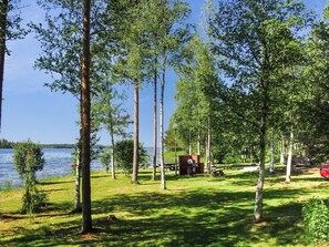 A lakeside campsite with picnic tables, a barbecue grill, and a small cabin. - Alakitkajärvi, takkusalmi by Interhome (Kuusamo)